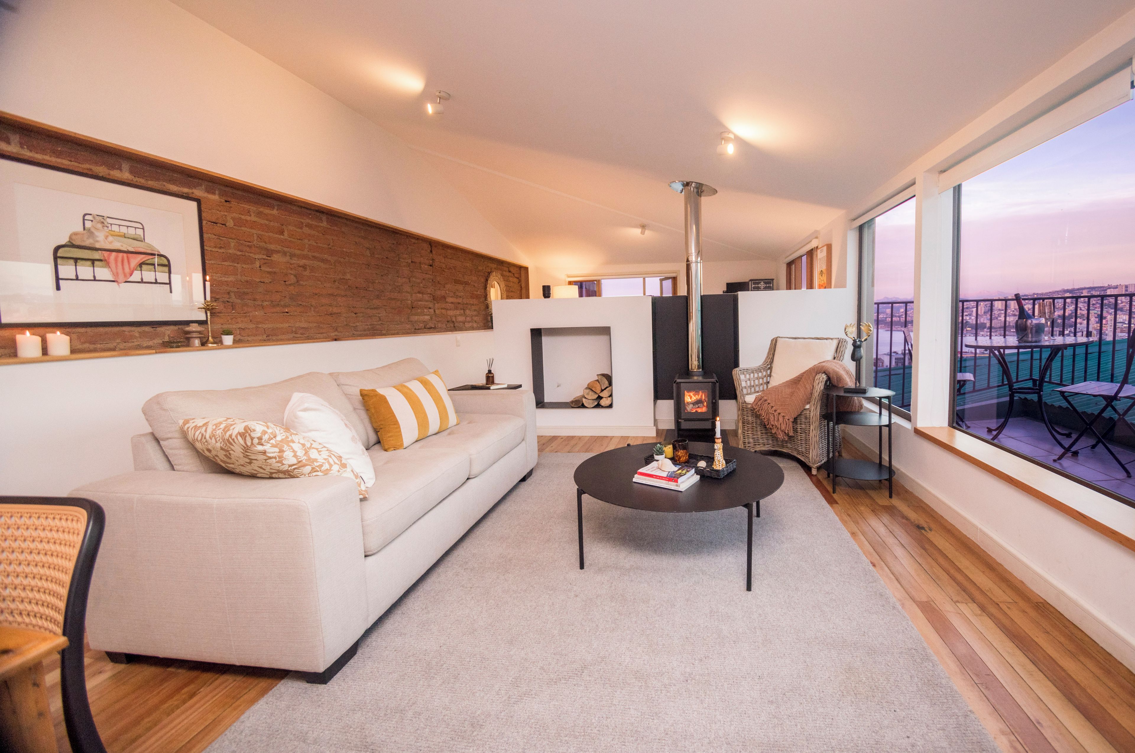 A modern living room with a sofa, a coffee table, and a fireplace.