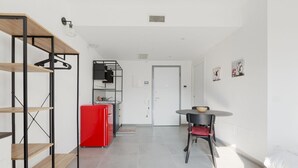 Um interior moderno com cozinha, mesa de jantar e cama.