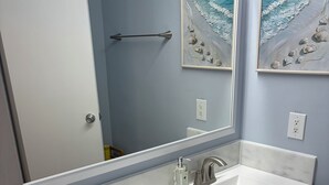 A bathroom with a double sink, a large mirror, and two framed paintings on the wall. - 2BR 1B condo Amelia island, 2 blocks beach 2 miles downtown 1 mile Fort Clinch (Fernandina Beach)