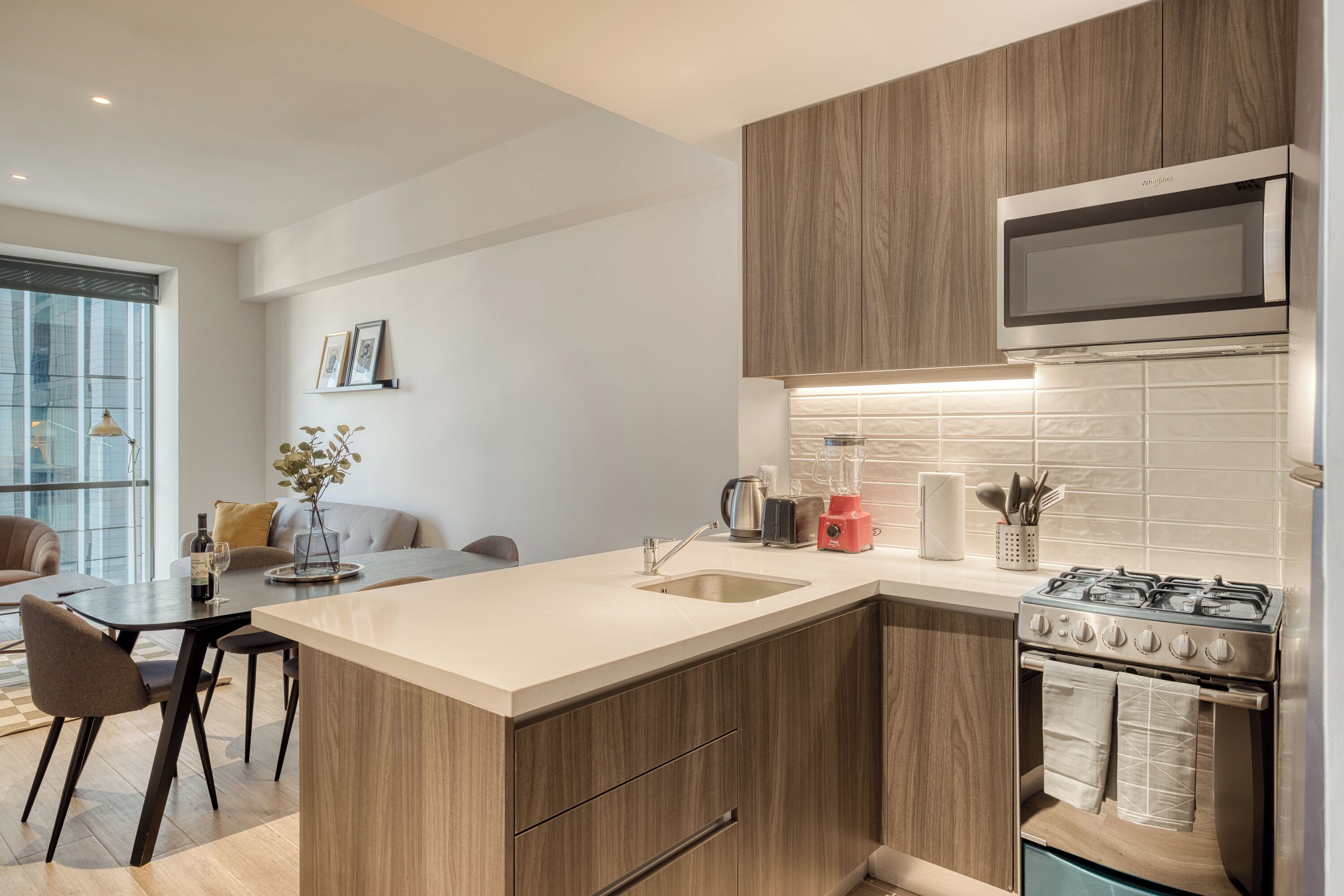 A modern kitchen with wooden cabinets, a built-in microwave, and a gas stove.