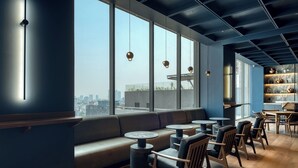 A modern interior with a large window, seating area, and tables. - Nido x Gran Ciudad Nuevo Polanco (Mexico City)