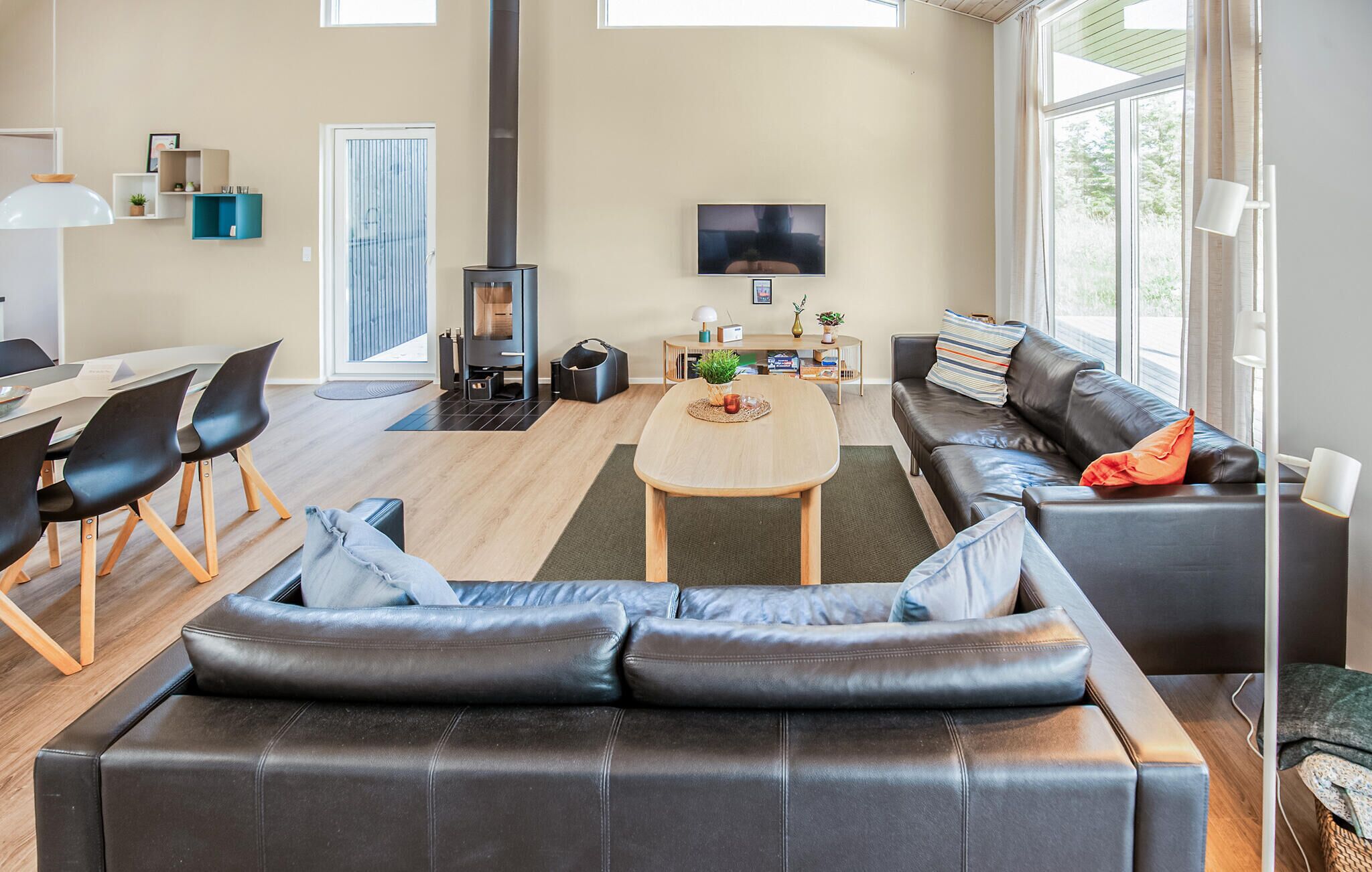 Un salon moderne avec un canapé, une table basse, un téléviseur et une cheminée.