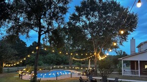 A backyard with a swimming pool, string lights, and outdoor furniture. - Beautiful Private 30 Acre Nature Retreat/Pool
Ideal for family/groups sleeps 16 (Plantersville)