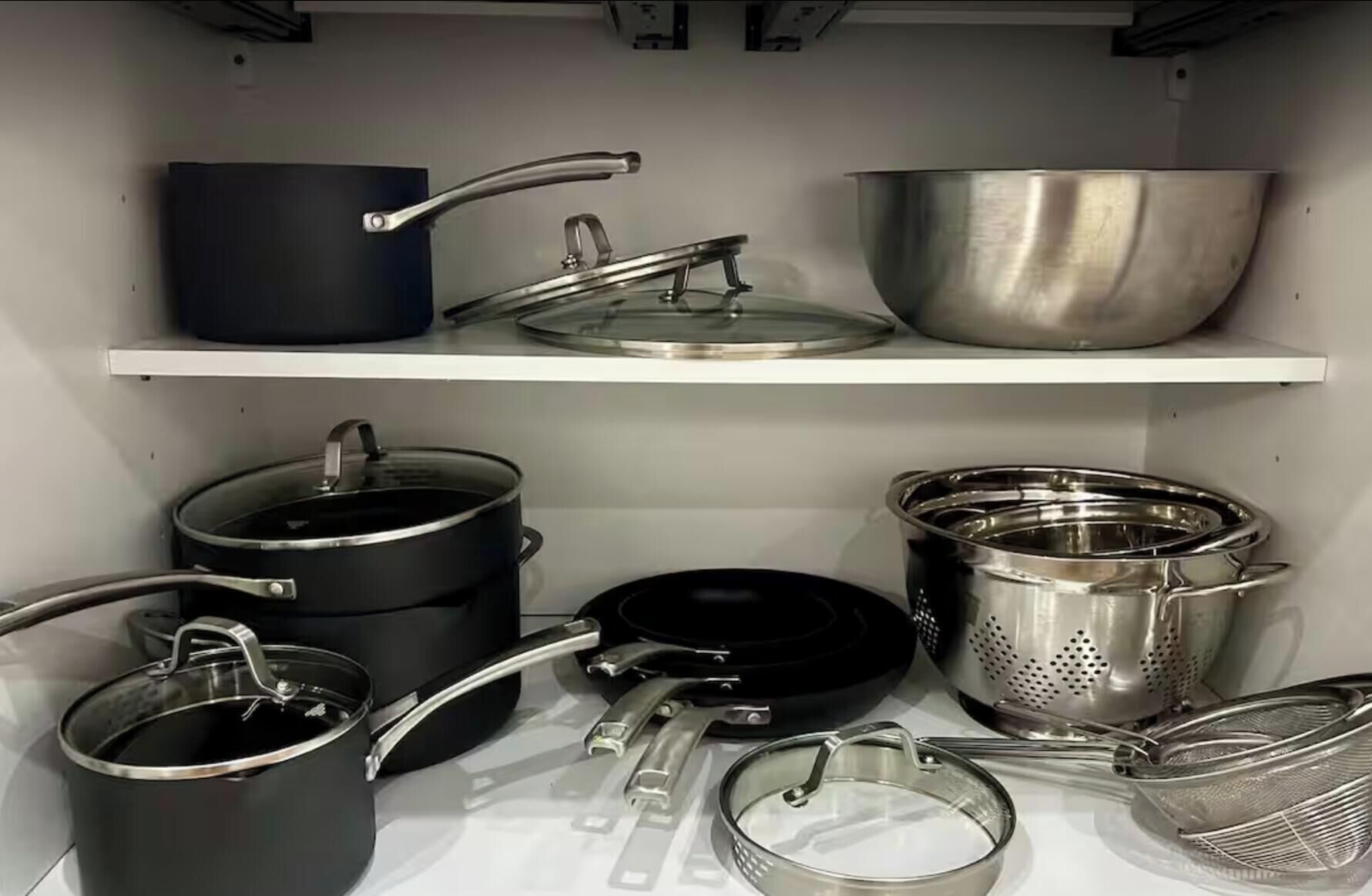 Una cocina con diferentes ollas y sartenes en estantes.