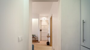 A hallway with a wooden floor, white walls, and a door at the end. - Anjos City Center Apartment by Homing (Lisbon)