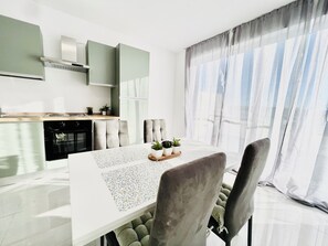 Apartamento premium, vista para a cidade | Cozinha privada | Geladeira grande, fogão, cooktop, talheres/pratos/utensílios de cozinha