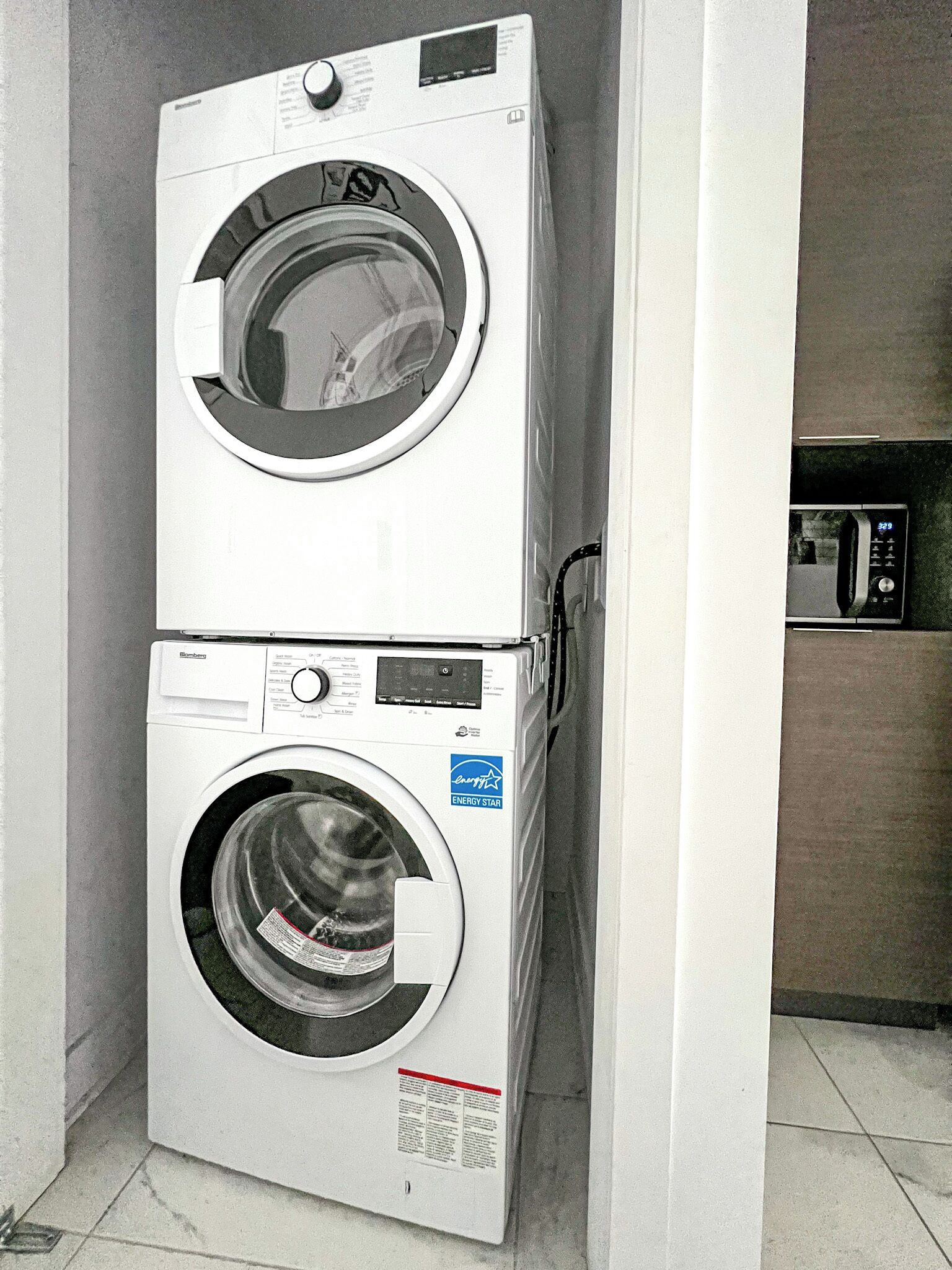 Una lavadora y secadora apiladas en un cuarto de lavado.