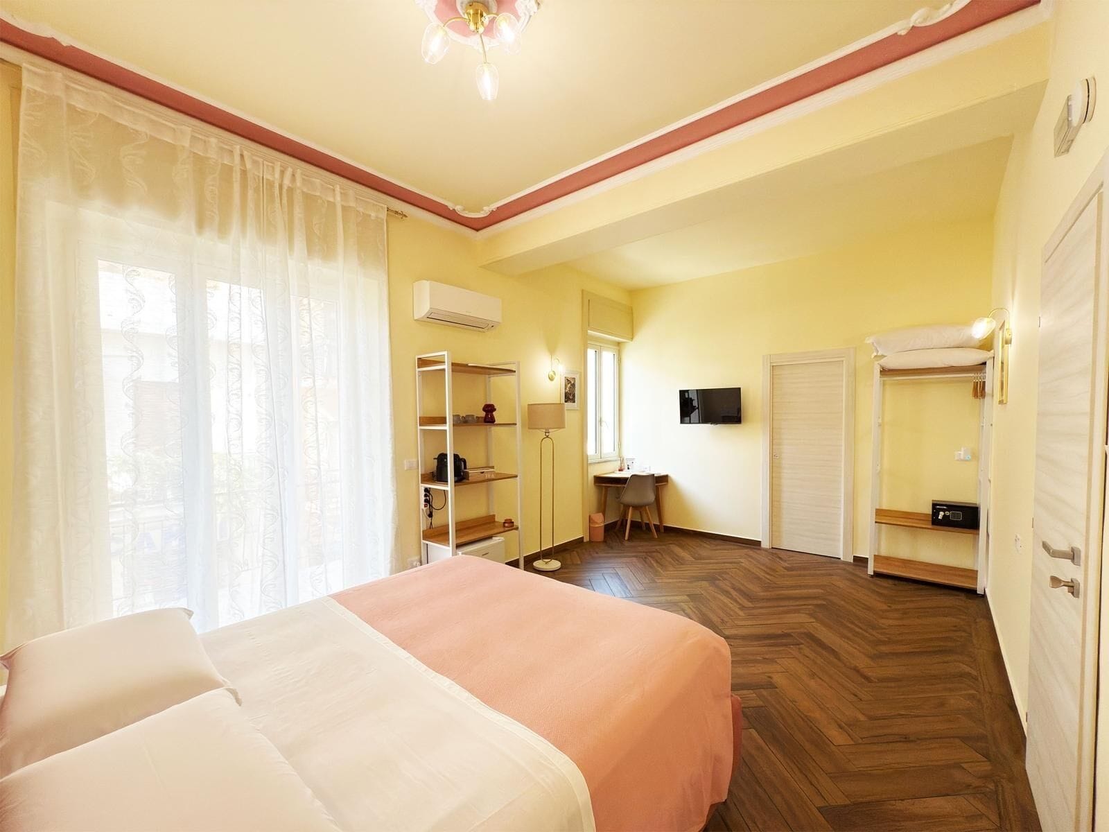 A bedroom with a bed, a desk, a chair, a TV, and a wardrobe.
