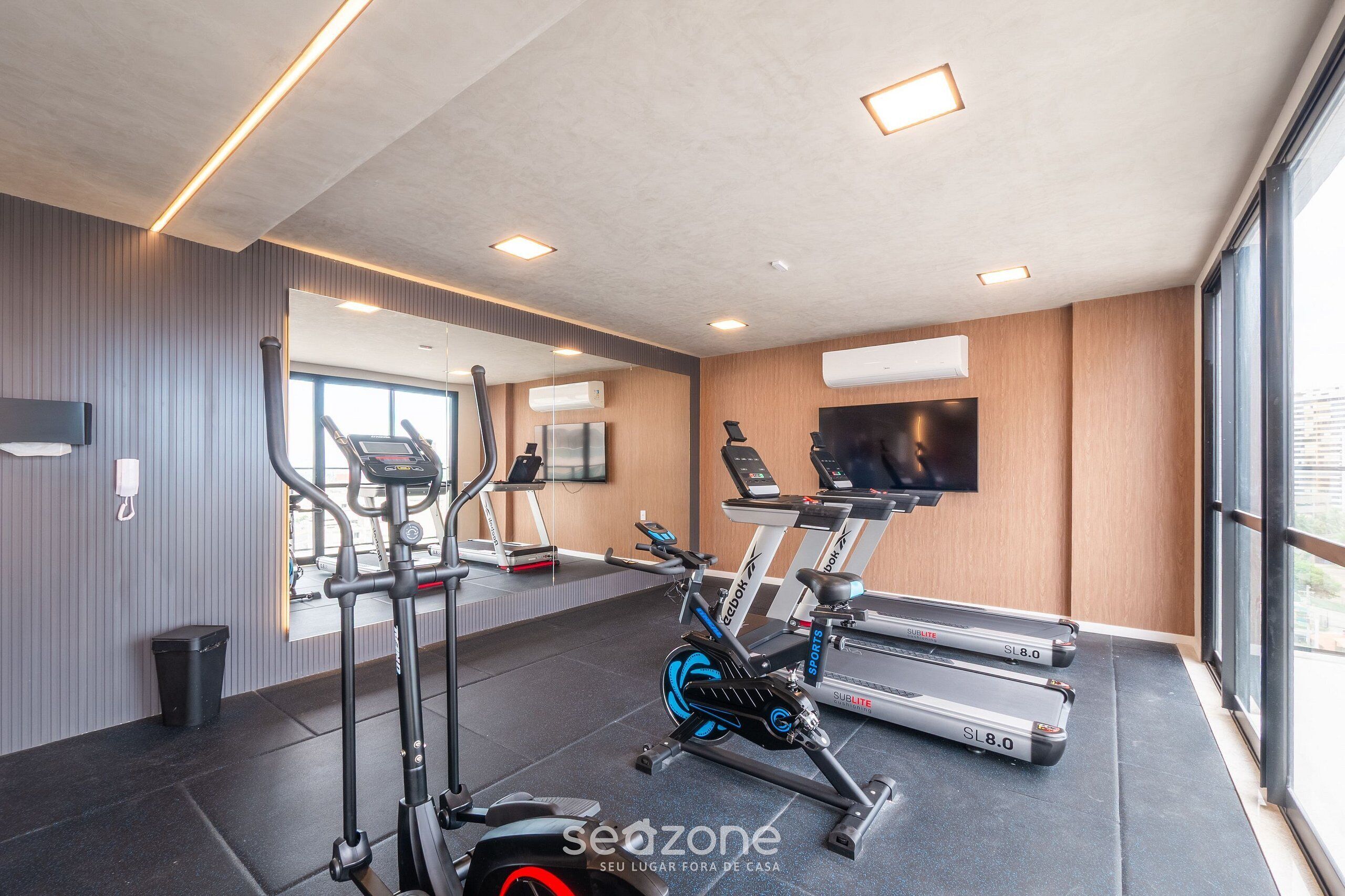 A gym with treadmills, an elliptical, and a stationary bike.