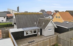 A residential area with houses featuring various roof styles and a small shed with a metal roof. - Nice home in Thyborøn with WiFi (Thyborøn)