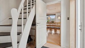 A staircase leading to a dining area with a wooden floor and a view of the outside. - Nice home in Thyborøn with WiFi (Thyborøn)