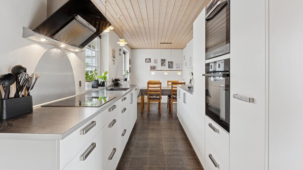 A modern kitchen with white cabinetry, a central island, a built-in oven, and a wooden ceiling. - Nice home in Thyborøn with WiFi (Thyborøn)
