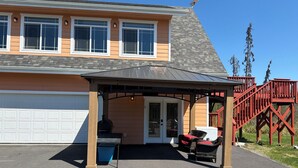 Uma casa com varanda coberta, garagem e escadaria vermelha.