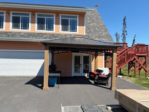 A house with a covered patio, a garage, and a red staircase.