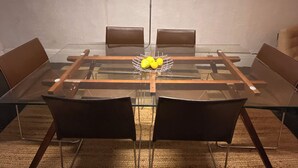 Een vergaderzaal met een glazen tafel, vier stoelen en een fruitmand.