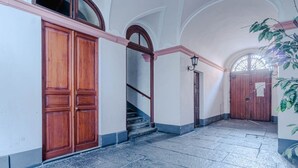 Ein Flur mit einer Holztür, einer Treppe und einem großen Rundbogenfenster.