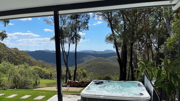 A hot tub on a balcony with a view of a mountainous landscape. - Valley View Escape: Wentworth Falls Blue Mountains (Wentworth Falls)