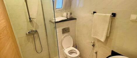 Un baño moderno con ducha de vidrio, inodoro y lavamanos.