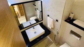 A modern bathroom with a black sink, white toilet, and a large mirror. - El Djanoub Hotel (Ghardaia)