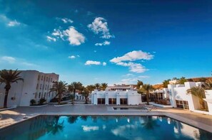 Ein Poolbereich mit blauem Himmel und weißen Gebäuden.