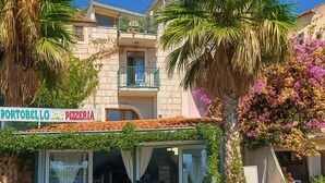 Een restaurant genaamd Portobello Bar Pizzeria met terras en balkon.
