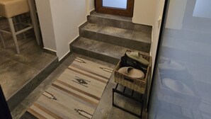 En trappa med en mönstrad matta och en korg av rotting med tofflor i.