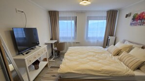 A hotel room with a bed, a TV, a desk, and a chair. - Villa Bella Vista - One Bedroom apartment with Balcony and View (Ivanec)