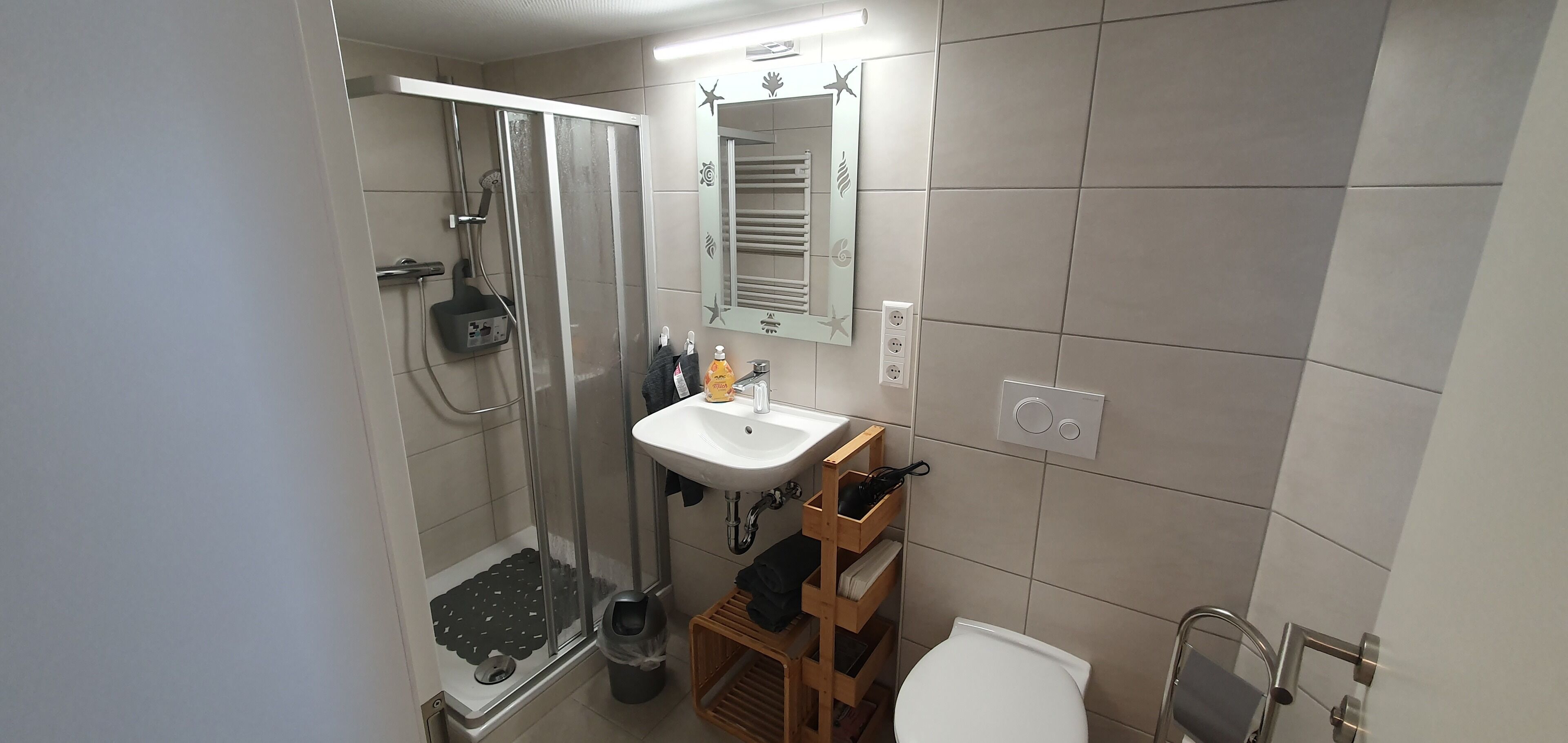 Ein Badezimmer mit Dusche, Waschbecken und Toilette.
