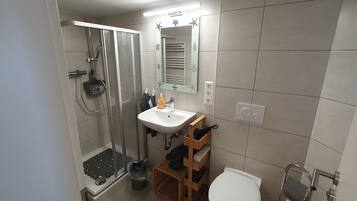 Ein Badezimmer mit Dusche, Waschbecken und Toilette.