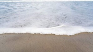 Ein Strand mit sanft anschwellenden Wellen.