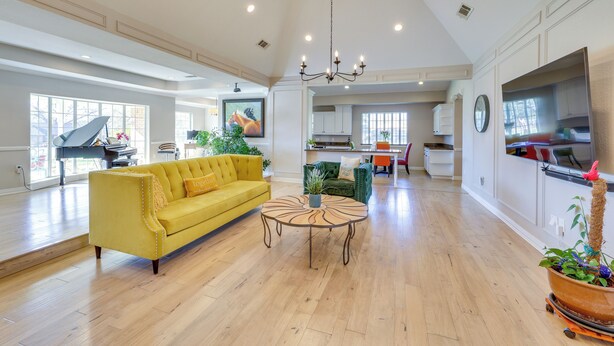 A spacious living room with a yellow sofa, a round coffee table, and a chandelier. - Work & Unwind, Stylish Sunnyvale Retreat! (Sunnyvale)