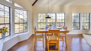 A dining area with a wooden table and chairs, large windows, and a hanging pendant light. - Quiet & Convenient Unit, 7 Mi to Lake Ray Hubbard! (Sunnyvale)