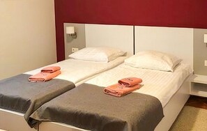 Un lit double avec deux oreillers et une table de chevet avec une lampe.