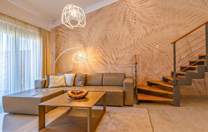 A modern living room with a sofa, a coffee table, a staircase, and a unique wall design. - Beautiful apartment in Medulin (Medulin)