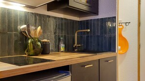 Une cuisine moderne avec des meubles de couleur sombre, un four à micro-ondes, un évier et un lave-vaisselle.