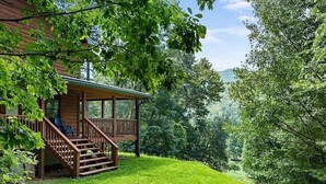 Una baita con un patio in legno e scale che conducono a un portico.