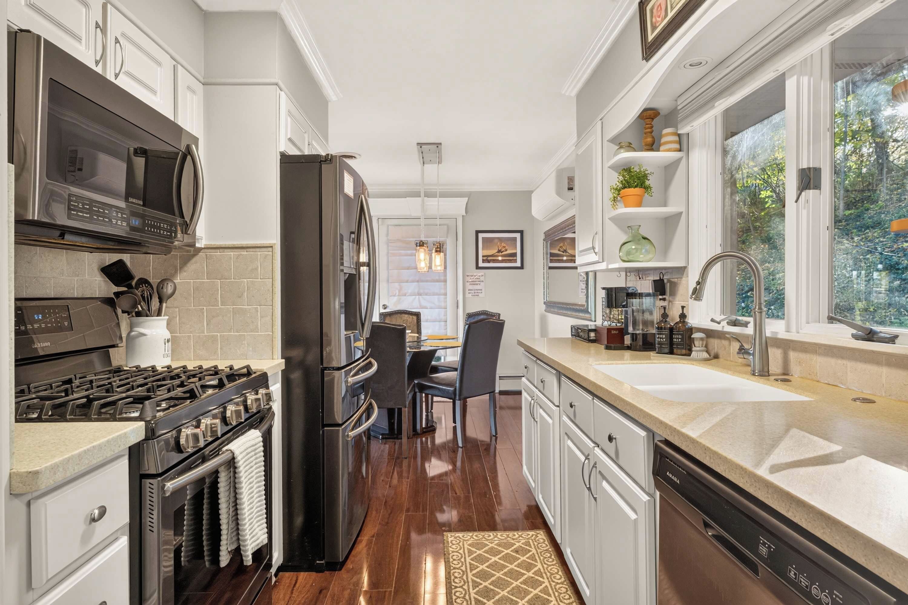 A modern kitchen with a stove, oven, microwave, refrigerator, and a dishwasher.