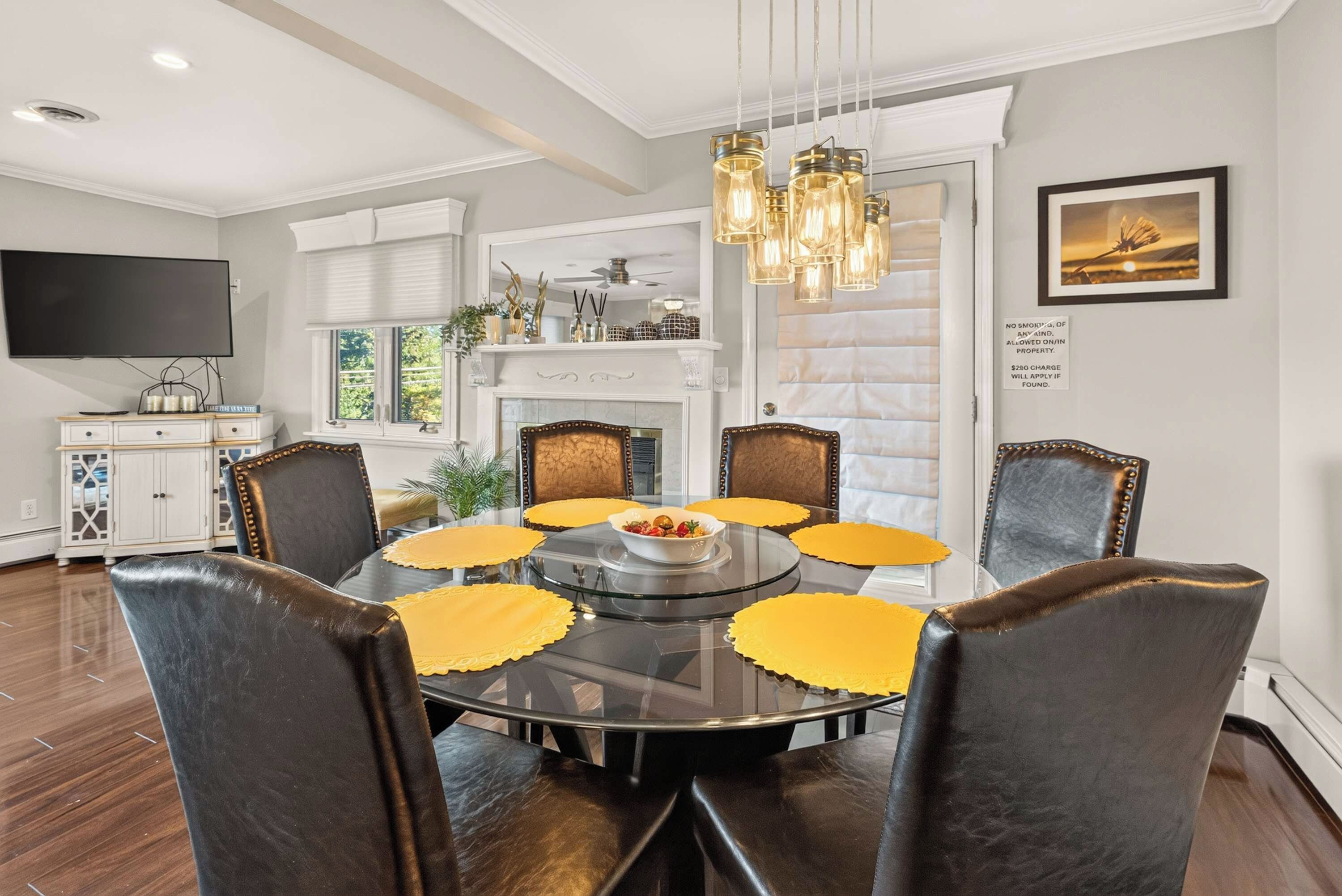 A dining area with a round table, chairs, and yellow placemats.