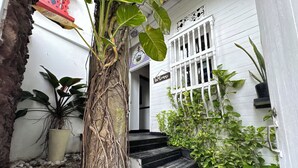 A white building with a wooden staircase leading to a door marked "Welcome". - Auaecoco Hotel (Cartagena)
