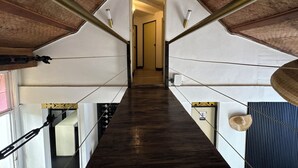 A narrow, wooden staircase with a high ceiling and exposed beams, leading to a doorway. - Auaecoco Hotel (Cartagena)