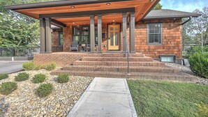 A modern two-story house with a covered porch, brick exterior, and a small front yard with gravel and shrubs. - Modern 4BD / 4.5BA Home Near ETSU, Mountain Home VA, JCMC, & Downtown JC (Johnson City)