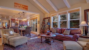 A spacious living room with a fireplace, a dining area, and a kitchen visible through an open door. - Cozy Ketchum Retreat - Pet Friendly! (Ketchum)
