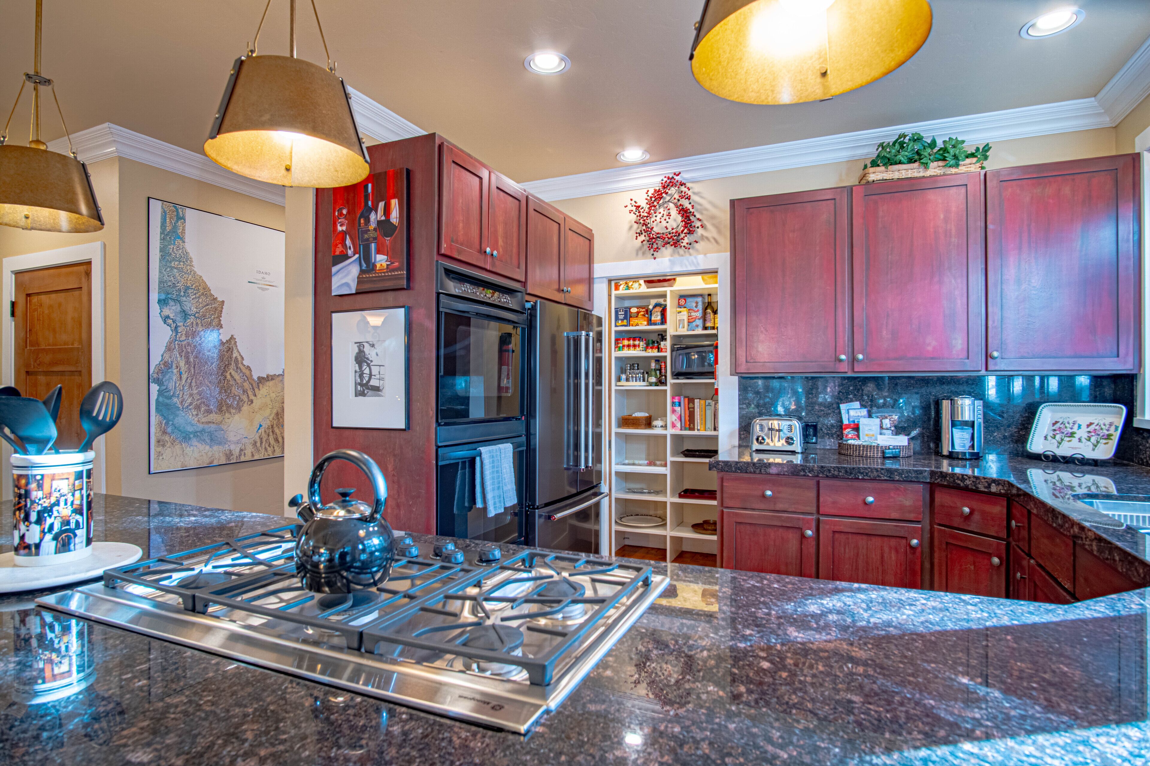 A modern kitchen with granite countertops, stainless steel appliances, and wooden cabinets.