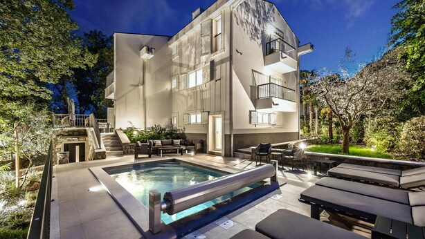A modern two-story building with a swimming pool, outdoor seating, and a well-maintained garden. - Luxurious home in Opric with sauna (Opric)