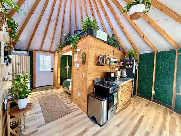 Um interior acolhedor, em madeira, com cozinha, área de refeições e espaço para dormir.