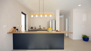 A modern kitchen with a central island, a built-in sink, and a stainless steel refrigerator. - Lovely home in Rogoznica (Rogoznica)