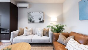 Een woonkamer met een bank, een bijzettafeltje en een plant.
