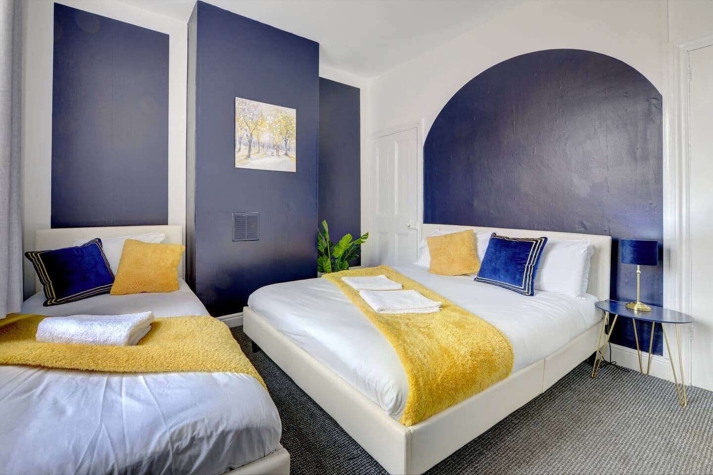 Ein Hotelzimmer mit zwei Betten, einem großen Bogenfenster und einem Bild an der Wand.