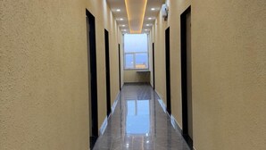 Un long couloir étroit, doté d’un sol brillant et réfléchissant, et d’un éclairage encastré au plafond.