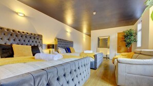 Una habitación de hotel moderna con una cama grande, un sofá y una mesita.